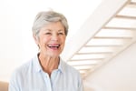 Retired woman smiling and laughing at home in living room