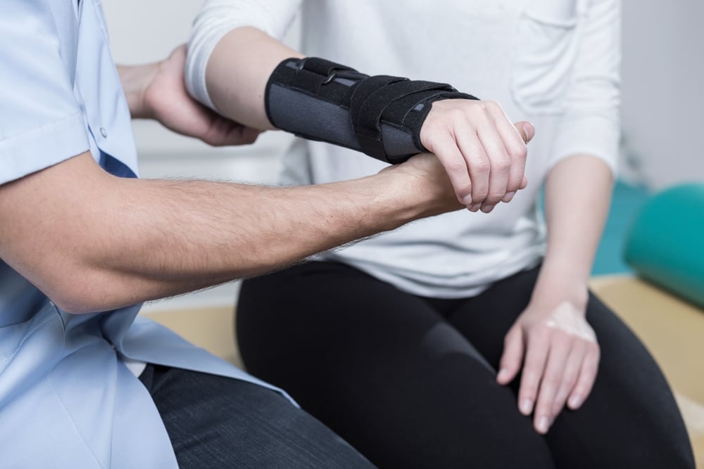Woman using wrist immobiliser after hands injury Woman using wrist immobiliser after hands injury